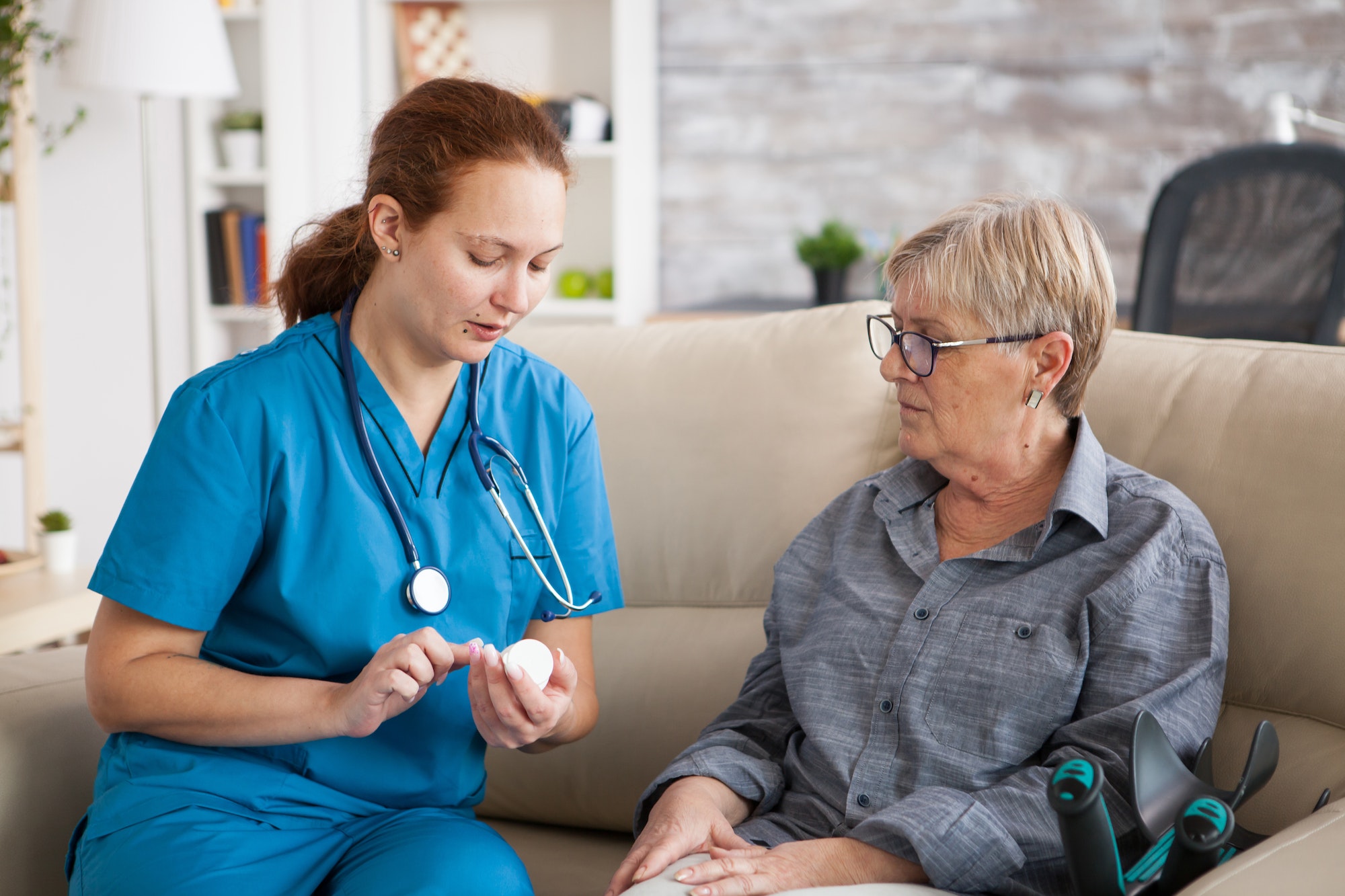 Nurse in nursing home helping senior woman